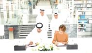 Minister of State and President of Qatar National Library H E Dr. Hamad bin Abdulaziz Al Kawari (right, standing) and Chairman of Qatar’s General Authority of Customs H E Ahmed bin Abdullah Al Jamal witness the agreement signing ceremony. 