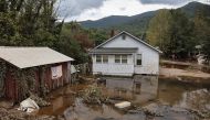 An American flag hangs above floodwaters remaining from Hurricane Helene on October 4, 2024 in Swannanoa, North Carolina. Photo by MARIO TAMA / GETTY IMAGES NORTH AMERICA / Getty Images via AFP.