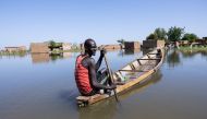 A man navigates a pirogue between the houses of the Tougoude district, in the south-east of Ndjamena's ninth arrondissement, flooded by the Logone River, on October 8, 2024. (Photo by Joris Bolomey / AFP)
