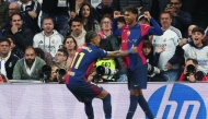 Barcelona's Spanish forward #19 Lamine Yamal (R) celebrates scoring their third goal with teammate Barcelona's Brazilian forward #11 Raphinha during the Spanish league football match between Real Madrid CF and FC Barcelona at the Santiago Bernabeu stadium in Madrid on October 26, 2024. (Photo by Pierre-Philippe MARCOU / AFP)