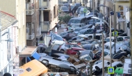 Pedestrians stand next to piled up cars following deadly floods in Sedavi, south of Valencia, eastern Spain, on October 30, 2024. (Photo by Jose Jordan / AFP)
