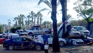 A man talks on the phone near car wreckages towed away following devastating flooding in Sedavi, south of Valencia, eastern Spain, on November 5, 2024. The death toll from Spain's worst floods in a generation has climbed to 217, according to rescuers. Photo by JOSE JORDAN / AFP.