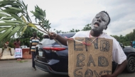 File: A protestor hold a placard a protest against  high living costs in Africa’s most-populous nation, in Abuja on August 2, 2024. (Photo by Kola Sulaimon / AFP)

