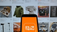 (FILES) This photograph shows the logo of Chinese e-commerce company Temu displayed on a mobile phone in front of a screen showing the company's website in Brussels on November 4, 2024. (Photo by Nicolas TUCAT / AFP)
