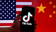 File: In this photo illustration the social media application logo for TikTok is displayed on the screen of an iPhone in front of a US flag and Chinese flag background in Washington, DC, on March 16, 2023. (Photo by Olivier Douliery / AFP)

