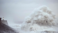 Waves crash against the sea wall and lighthouse at Porthcawl, south Wales, on December 7, 2024. (Photo by Ben Stansall / AFP)
 