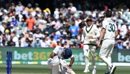 Australia's captain Pat Cummins (R) celebrates his dismissal of India's Nitish Kumar Reddy with teammate Usman Khawaja on the third day of the second Test cricket match between Australia and India at the Adelaide Oval in Adelaide on December 8, 2024. (Photo by Michael ERREY / AFP)