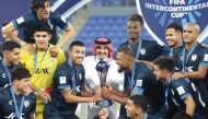 Qatar Stars League's CEO Hani Ballan presents the trophy as Pachuca's players celebrate after winning the 2024 FIFA Intercontinental Cup match, denominated the FIFA Derby of the Americas,  against Botafogo at Stadium 974 in Doha yesterday.