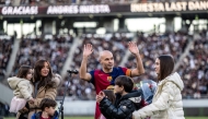 Spanish football legend Andres Iniesta (C) gestures as he is joined by his wife Anna Ortiz and his five children during his retirement ceremony after the exhibition football match between former Barcelona and Real Madrid players -- Barca Legends and Real Madrid Leyendas -- at Ajinomoto Stadium in Tokyo on December 15, 2024. (Photo by Philip Fong / AFP)