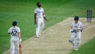 India's Jasprit Bumrah reacts after Australia's Travis Head (L) scores another boundary as Steve Smith (R) looks on during day two of the third cricket Test match between Australia and India at The Gabba in Brisbane on December 15, 2024. (Photo by Patrick Hamilton / AFP) 