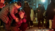 People react next to a makeshift memorial at the playground of Precko primary school, following a stabbing attack at the school which left one dead and several injured, in Zagreb, on December 20, 2024. (Photo by DAMIR SENCAR / AFP)
