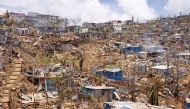 This photograph shows a general view of damaged shelters and houses in the town of Vahibe, on the outskirts of Mamoudzou, on the French Indian Ocean territory of Mayotte, on December 24, 2024, a week after the cyclone Chido's passage over the archipelago. (Photo by PATRICK MEINHARDT / AFP)
