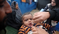 A Palestinian child receives a polio vaccine at a camp for displaced people in Nuseirat in the central Gaza Strip on February 23, 2025. Photo by Eyad BABA / AFP