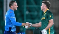 England's captain Jos Buttler (L) and South Africa's David Miller shake hands at the end of the ICC Champions Trophy one-day international in Karachi on March 1, 2025. (Photo by Asif Hassan / AFP)
