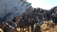 Palestinians search through the rubble of a building at the site of an Israeli strike in Khan Yunis in the southern Gaza Strip on March 23, 2025. (Photo by AFP)