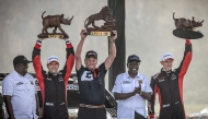 Toyota Gazoo Racing WRT's British driver Elfyn Evans (R) and co-driver Scott Martin (2nd L) hold their trophies as they pose for the media with President of Kenya William Ruto (2nd R) after winning the World Rally Championship (WRC) Safari Rally Kenya in Naivasha on March 23, 2025. (Photo by Luis TATO / AFP)
