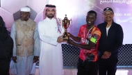 NHRC Secretary-General H E Sultan bin Hassan Al Jamali awarding the trophy. Ambassador of Uganda H E Mohammed Baswari Kezaala (first left) is also seen.