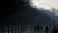 Cyclists ride past joggers running in Hyde Park in central London on March 19, 2025. (Photo by JUSTIN TALLIS / AFP)
