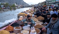Afghans buy dry fruits along the Kabul river ahead of Eid Al Fitr, in downtown Kabul on March 27, 2025. (Photo by Wakil Kohsar / AFP)
