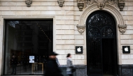 (Files) Pedestrians walk past an Apple store on the Champs-Elysees avenue in Paris, on March 18, 2024. (Photo by Julie Sebadelha / AFP)