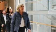 President of the parliamentary group of the French far-right Rassemblement National (RN) party, Marine Le Pen (R), walks followed by co-defendant French member of European Parliament Catherine Griset (L) as they exit a courtroom in Paris, on March 31, 2025. (Photo by Alain Jocard / AFP)