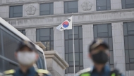 Police officers stand a road in Seoul on April 1, 2025 in front of the Constitutional Court, which will issue its long-awaited ruling on President Yoon Suk Yeol's impeachment on April 4, months after he was suspended for declaring martial law. (Photo by Pedro Pardo / AFP)