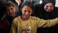 People cry as Palestinians mourn over the bodies of loved ones killed in overnight Israeli bombardment on northen Gaza, at the Ahli Arab Hospital, also known as the Maamadani (Baptist) Hospital, in Gaza City on April 3, 2025. (Photo by Omar AL-QATTAA / AFP)