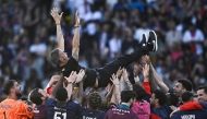 Paris-Saint Germain's players throw up in the air Paris Saint-Germain's Spanish headcoach Luis Enrique as they celebrate after winning the match and the French championship title after the French L1 football match between Paris Saint-Germain (PSG) and SCO Angers at The Parc des Princes Stadium in Paris on April 5, 2025. (Photo by JULIEN DE ROSA / AFP)
