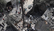 People inspect the destruction in a residential area in Deir al-Balah in the central Gaza Strip on April 7, 2025, following overnight Israeli airstrikes. (Photo by Eyad BABA / AFP)
