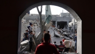 Children look at the destruction in a residential area in Deir al-Balah in the central Gaza Strip on April 7, 2025, following overnight Israeli airstrikes targeting the area. (Photo by Eyad BABA / AFP)

