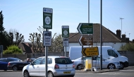 A photograph taken on April 2, 2025 shows signs indicating the ultra-low emission zone (ULEZ) in Hook, south west London. (Photo by Justin Tallis / AFP)
