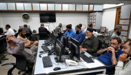 Stockbrokers monitor share prices on computers during a trading session at the Pakistan Stock Exchange (PSX) in Karachi on April 9, 2025.  (Photo by Rizwan Tabassum / AFP)
