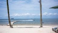 A jet-ski passes as two tourists swim at the beach at River Lodge, a hotel site located at Pointe-Denis on April 6, 2025. (Photo by Nao Mukadi / AFP)