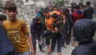 Palestinians help an injured man after an Israeli strike on the Manoun family home in Jabalia in the northern Gaza Strip on April 13, 2025. Photo by BASHAR TALEB / AFP.