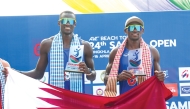 Cherif Younousse (left) and Ahmed Tijan celebrate with the Qatari flag after sealing the title.  