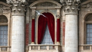 A seagull flies in front of the central loggia at St Peter's square following the death of Pope Francis in the Vatican on April 21, 2025. (Photo by Andreas Solaro / AFP)