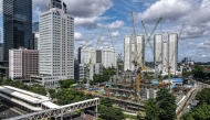 This aerial picture shows an under construction building among skyscrapers in Jakarta's business district on April 14, 2025. (Photo by BAY ISMOYO / AFP)