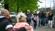 Students evacuate the high school Notre-Dame de Toutes-Aides before a Police Municipal officer surrounds the scene of crime with a Police tape after a knife attack, one student was killed and three other were wounded in Nantes, western France, on April 24, 2025. (Photo by Loic VENANCE / AFP)
