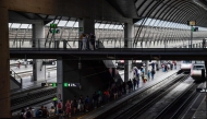 Passengers walk along a platform to board a train at Santa Justa railway station in Seville on April 29, 2025, the day after a massive power cut affecting the entire Iberian peninsula and the south of France. Photo by CRISTINA QUICLER / AFP
