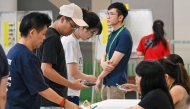 People register to vote in the general election at a polling station in Singapore on May 3, 2025. (Photo by Roslan Rahman / AFP)