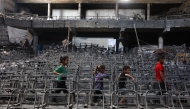 Displaced Palestinian children play at a damaged lecture hall at the Islamic University campus in Gaza City on May 1, 2025. Photo by Omar AL-QATTAA / AFP