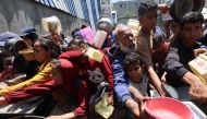Palestinians queue for a hot meal at a charity kitchen at the Nuseirat refugee camp in the central Gaza Strip on May 4, 2025. (Photo by Eyad Baba / AFP)