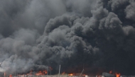 A handout picture provided by the Iranian Red Crescent (IRCS) on April 28, 2025, shows thick black smoke billowing at the scene of a massive explosion two days earlier at the Shahid Rajaee port dock southwest of Bandar Abbas in the Iranian province of Hormozgan. (Photo by Iranian Red Crescent / AFP)