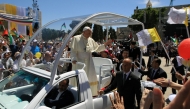 Pope Francis waves to the crowd, from his popemobile, as he arrives at the Manger Square before presiding over an open-air mass on May 25, 2014 outside the Church of the Nativity in the West Bank Biblical town of Bethlehem. Photo by Jack GUEZ / AFP