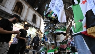 Syrians walk past shops in Damascus on May 5, 2025. (Photo by Louai Beshara / AFP)
