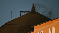 This photograph shows black smoke rising from the chimney of the Sistine Chapel signalling that cardinals failed to elect a new pope in the first ballot of their conclave in the Vatican on May 7, 2025. (Photo by Andreas Solaro / AFP)
