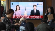 People watch a television screen showing a news broadcast with file footage of a North Korean missile test, at a train station in Seoul, yesterday. (AFP)