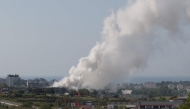 A picture taken on May 10, 2025 shows smoke billowing from a building storing pool cleaning products, in the coastal city of Vilanova i la Geltru, south of Barcelona. (Photo by Lluis Gene / AFP)