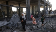 Displaced Palestinians walk amid the rubble of an UNRWA school-turned-shelter, heavily damaged in an overnight Israeli strike in Jabalia in the northern Gaza Strip on May 10, 2025. (Photo by BASHAR TALEB / AFP)
