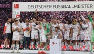 Bayern Munich players including English forward #09 Harry Kane celebrate with the trophy after the German first division Bundesliga football match between Bayern Munich and Borussia Moenchengladbach in Munich on May 10, 2025. (Photo by Alexandra BEIER / AFP)